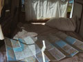 BulliHoliday Campingbus mieten Janine - unteres Bett mit ausgebreiteter Landkarte
